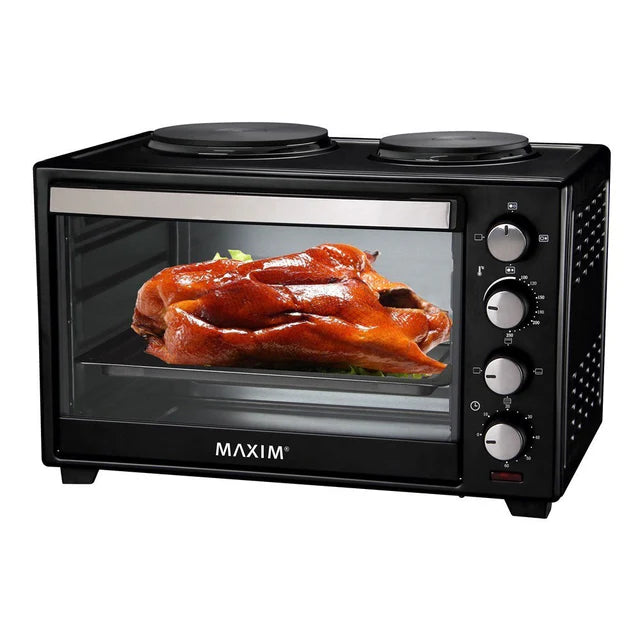 Black Maxim oven with a roasted chicken inside on a white background
