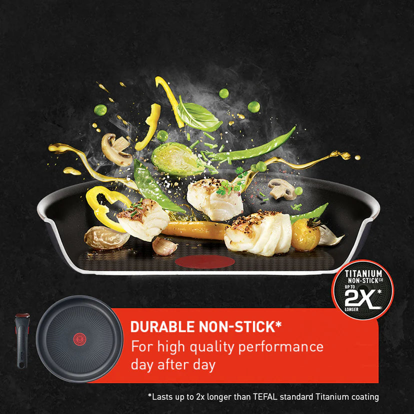 Non-stick frying pan with food and Tefal logo on a dark background
