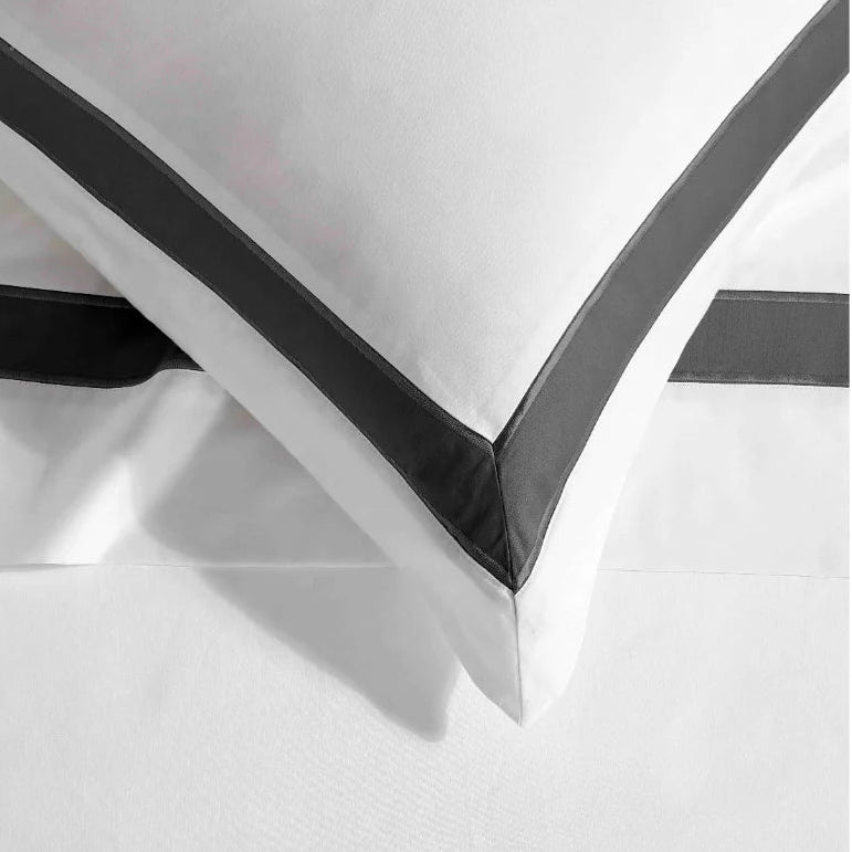White pillowcase with black trim on a white background