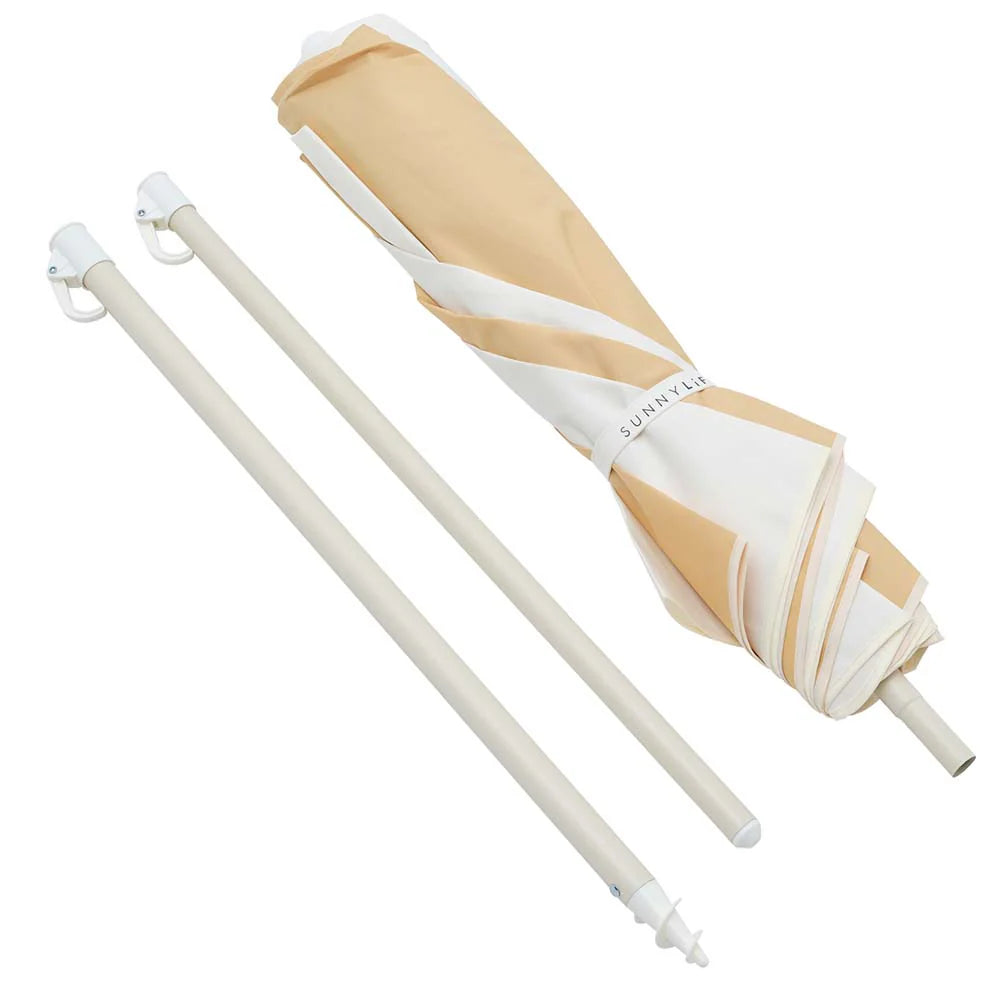 Beige and white umbrella with extended shaft on a white background