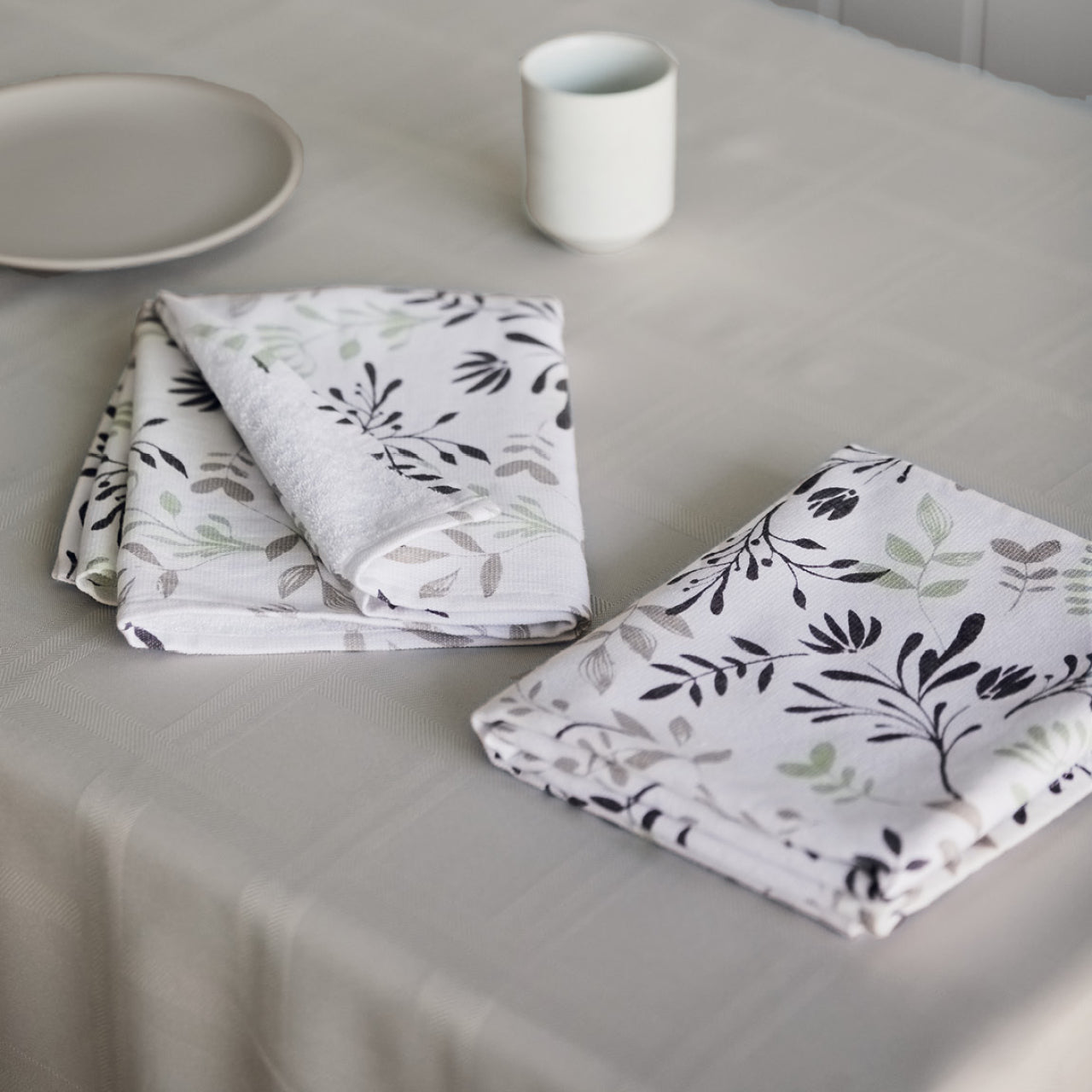 Lifestyle shot of Ambrosia Tea Towels on dining table with plate and glass