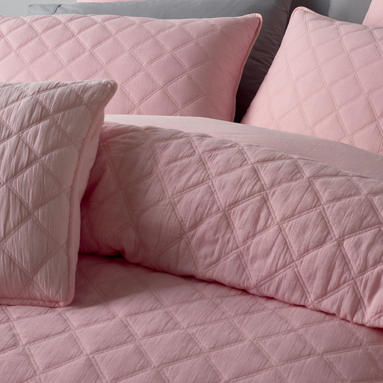 Zoomed in shot of Austin Pink Cushion Cover on bed