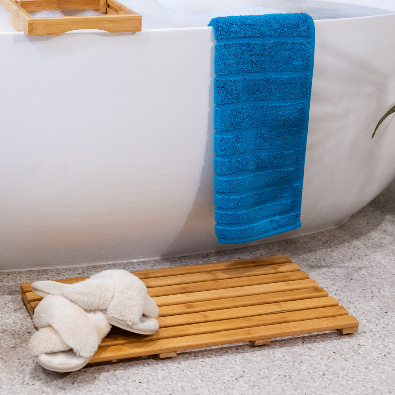 Lifestyle shot of Bamboo Bath Mat with slippers and towel