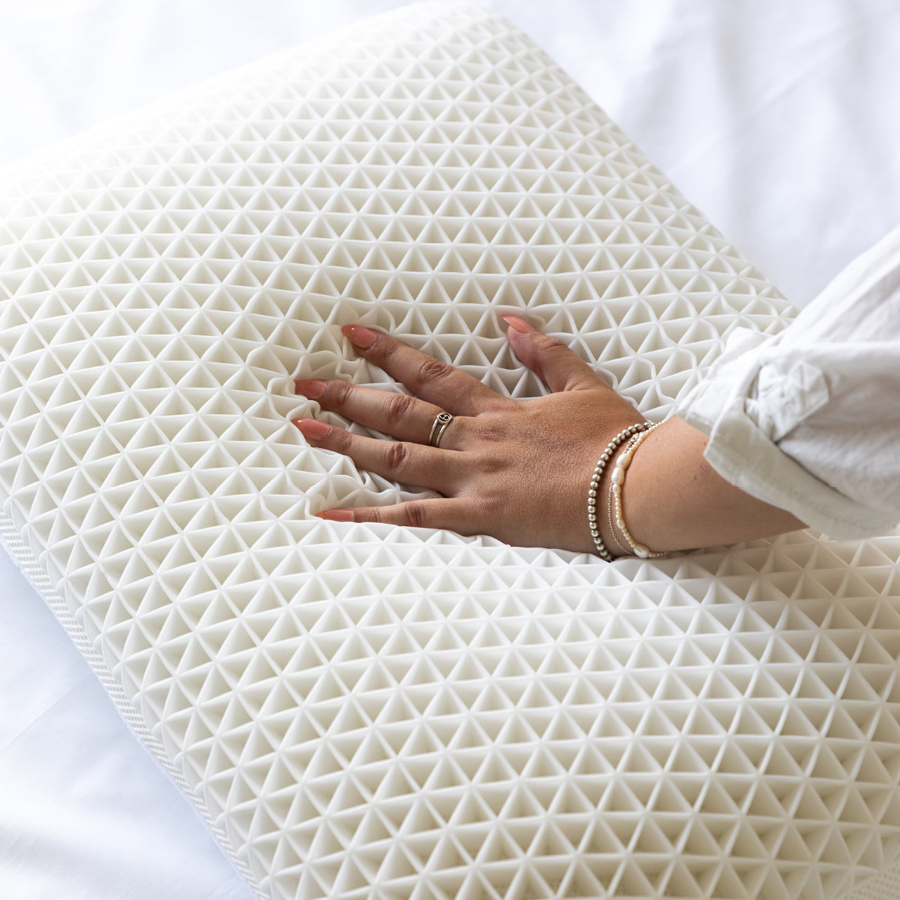 Lifestyle shot of woman pressing down on Cool Touch Pillow