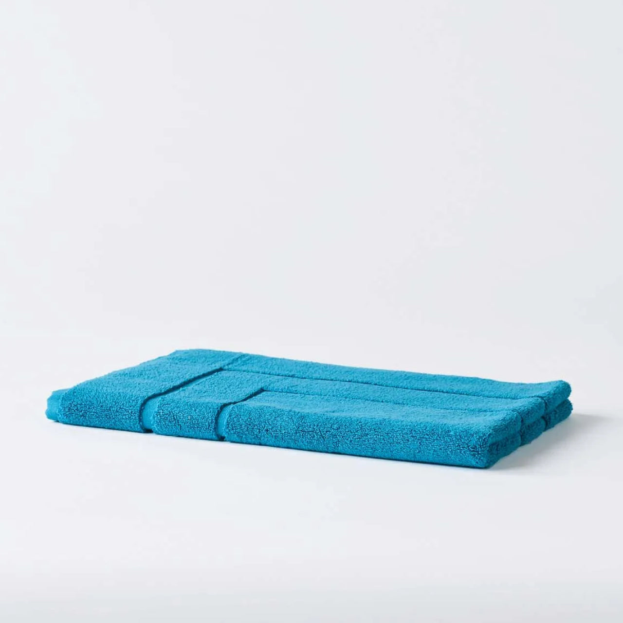 Cooper Bath Mat Peacock Blue on a white background