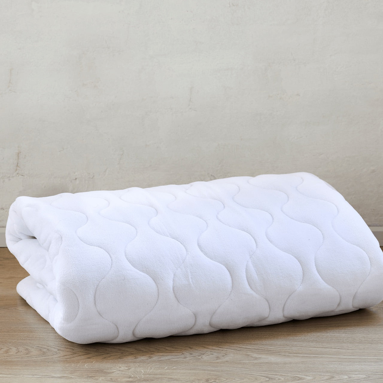 Coral Fleece Mattress Protector rolled up on floor