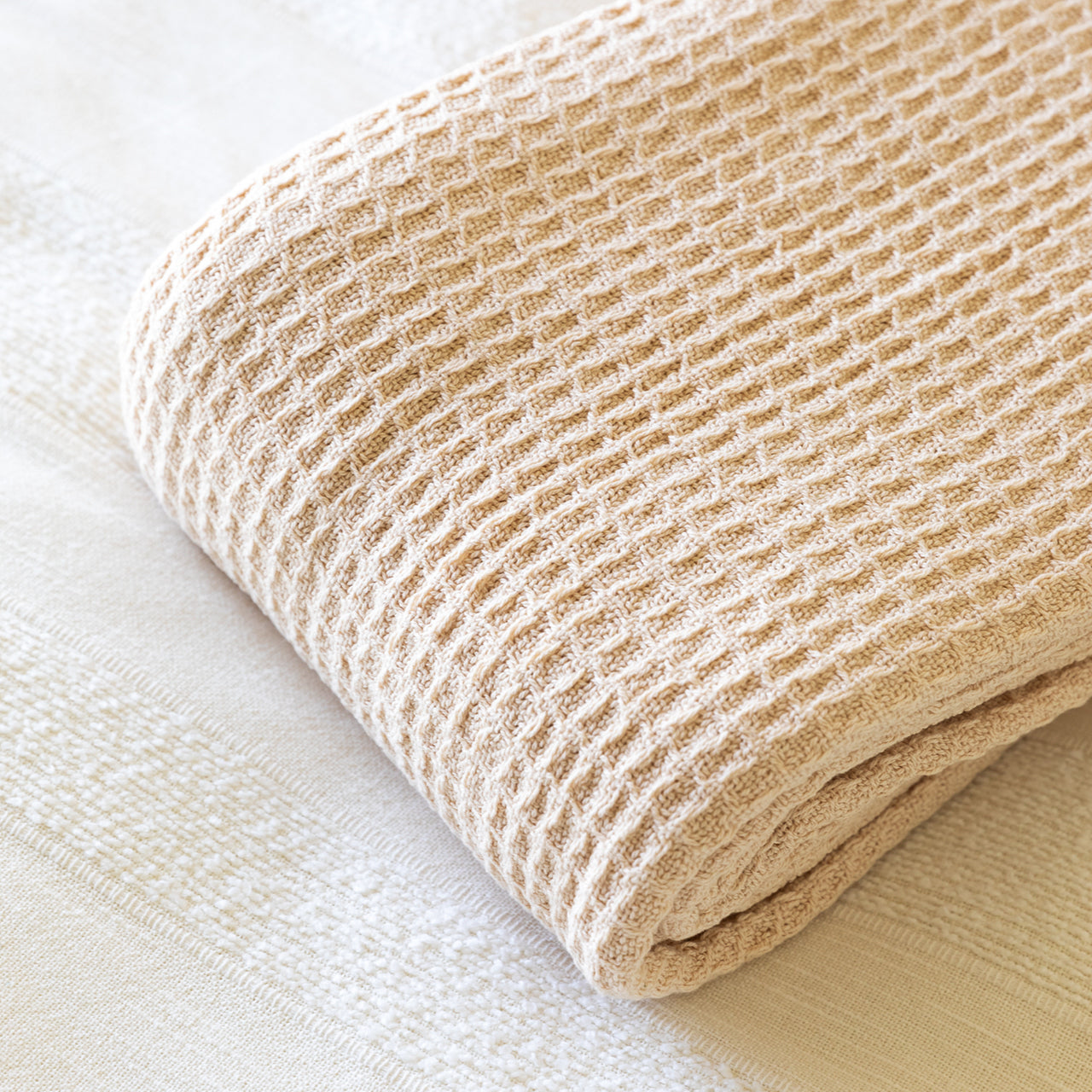 Cotton Blanket Natural folded up on bed