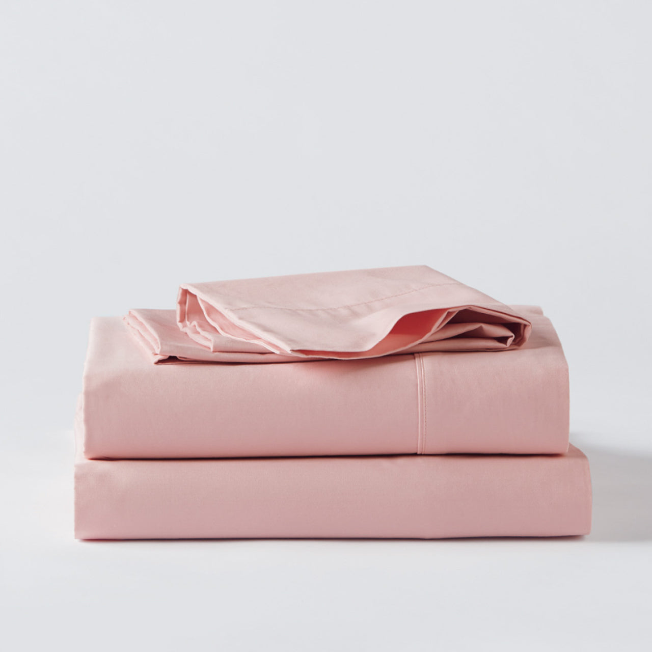 Cotton Blush Sheets folded up on floor
