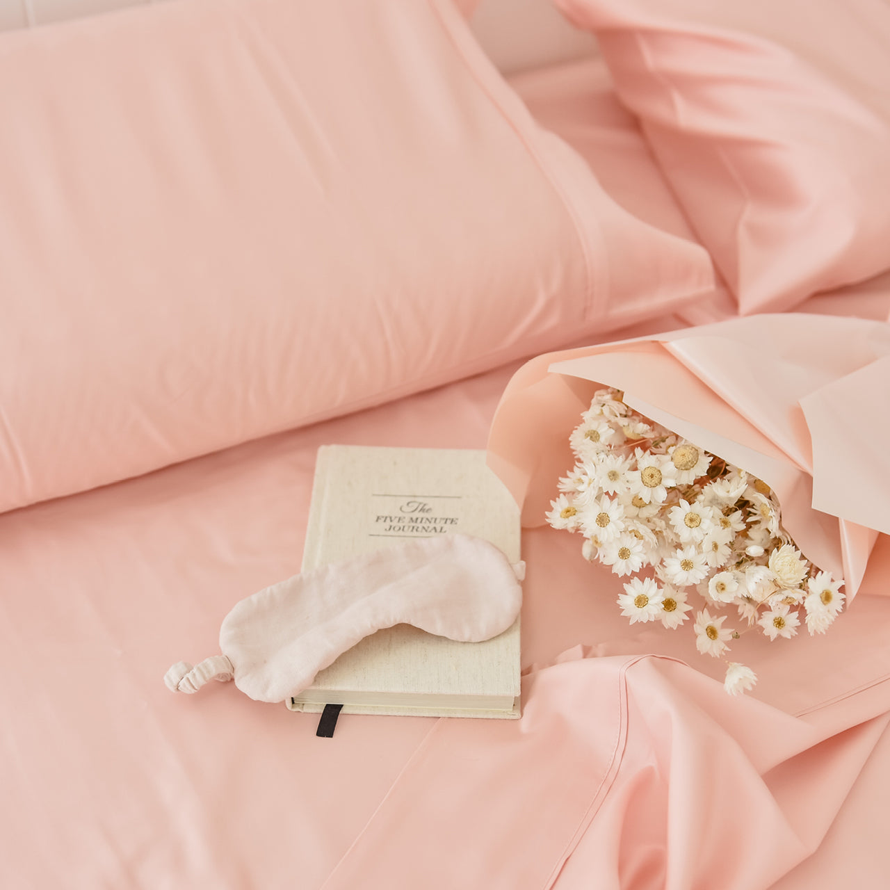 Lifestyle shot of Cotton Blush Sheets on bed with journal and flowers