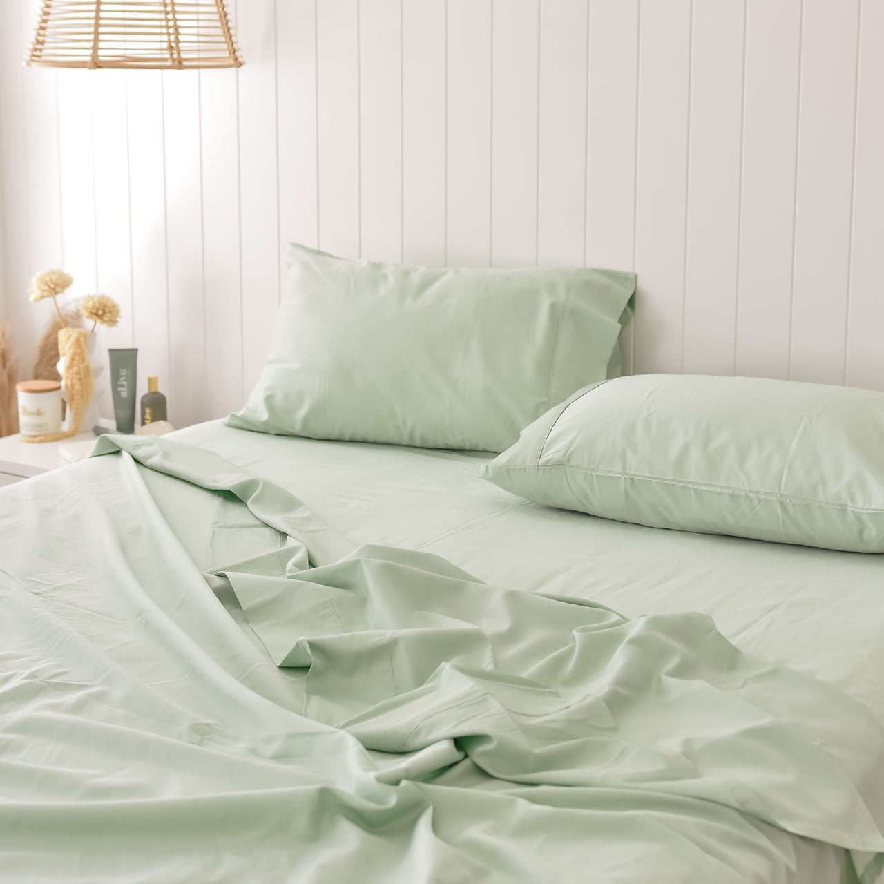 Lifestyle shot of Cotton Pistachio Sheets on bed