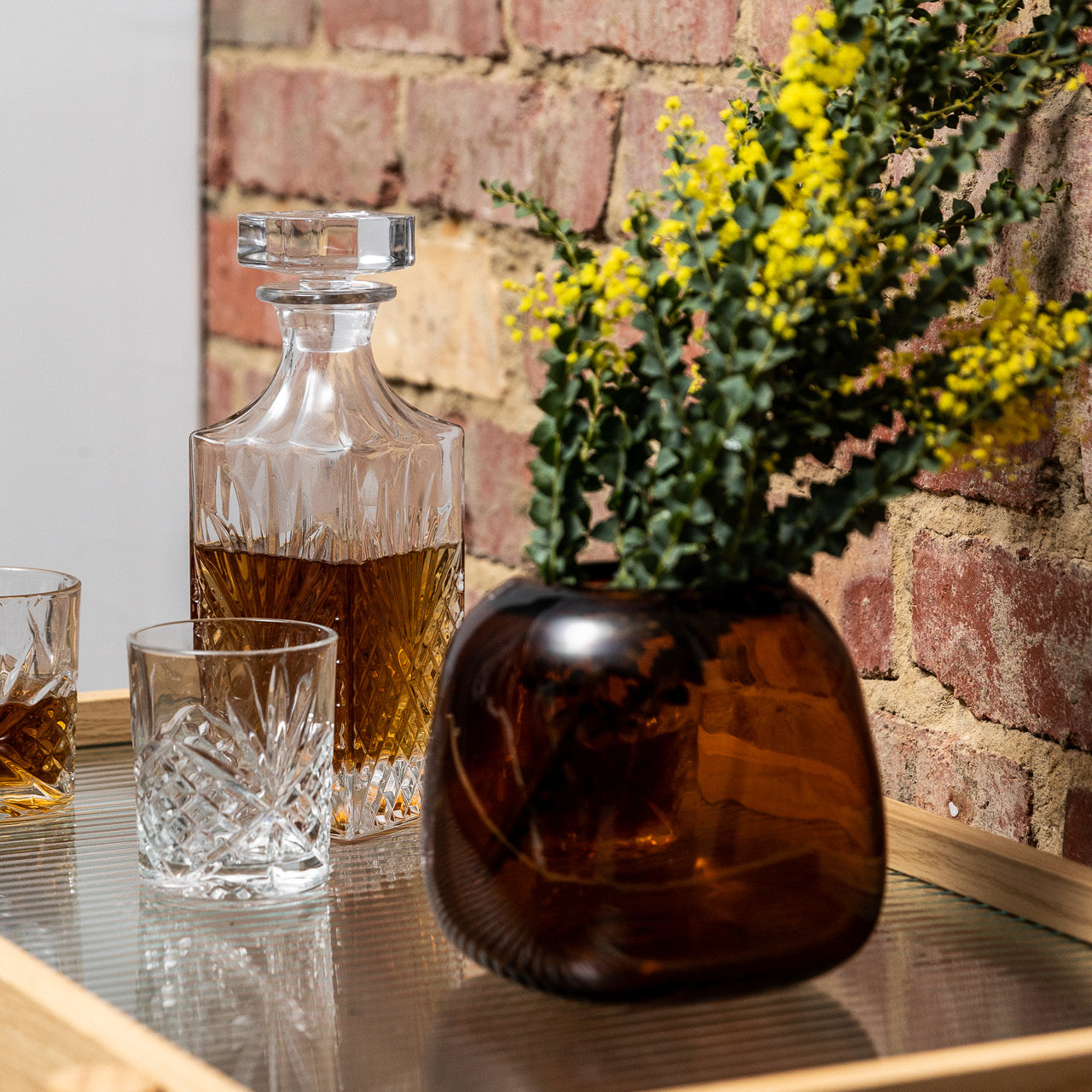 Lifestyle shot of Indiana Vase Amber 15cm on a bar cart