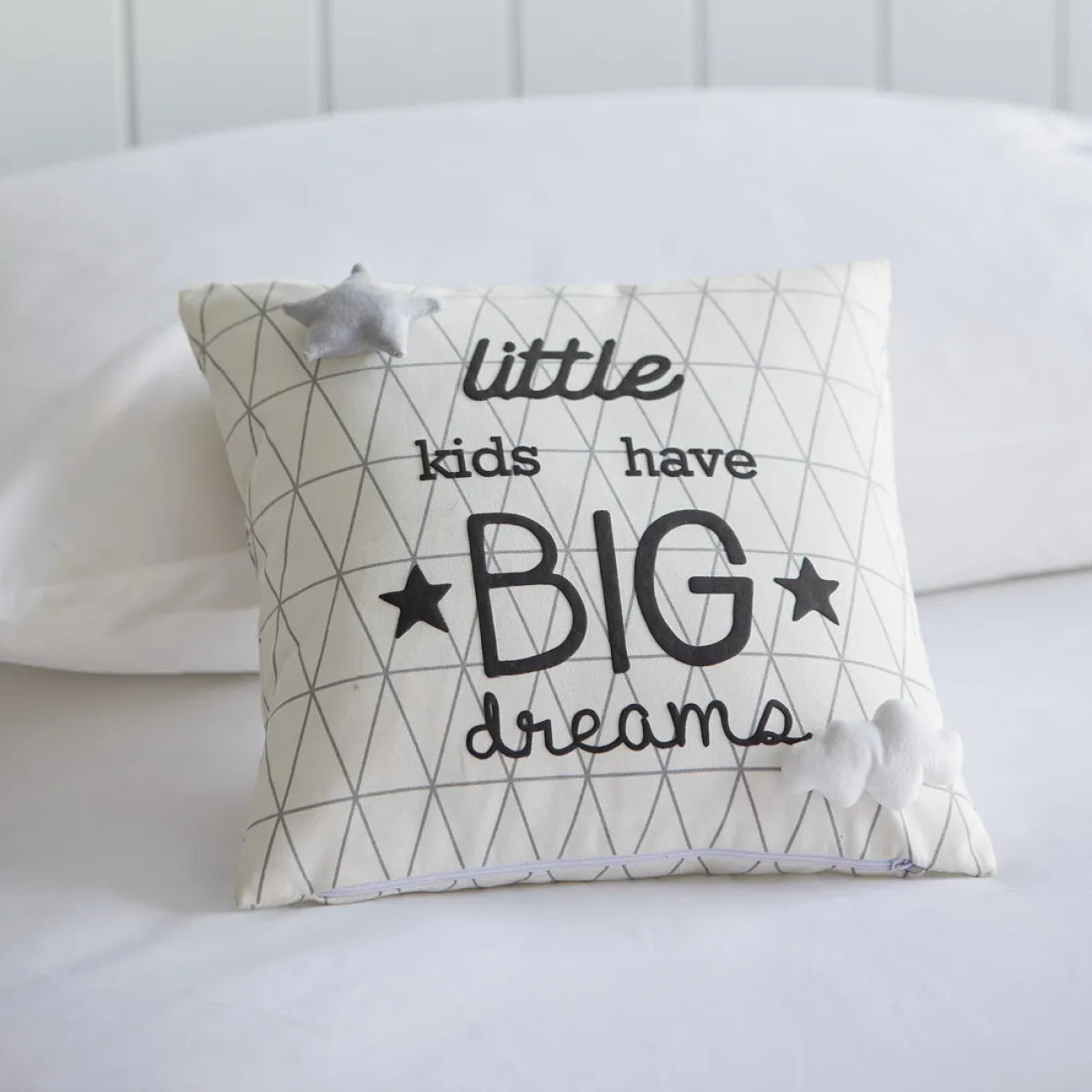 Dream Big Novelty Cushion sitting up on bed