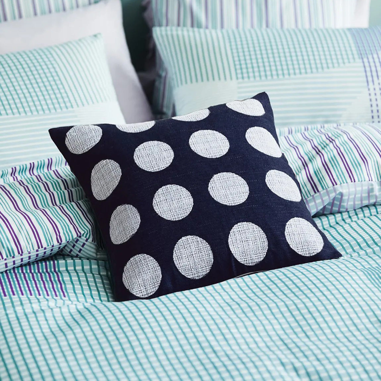 Close up shot of Lena Cushion Cover on bed
