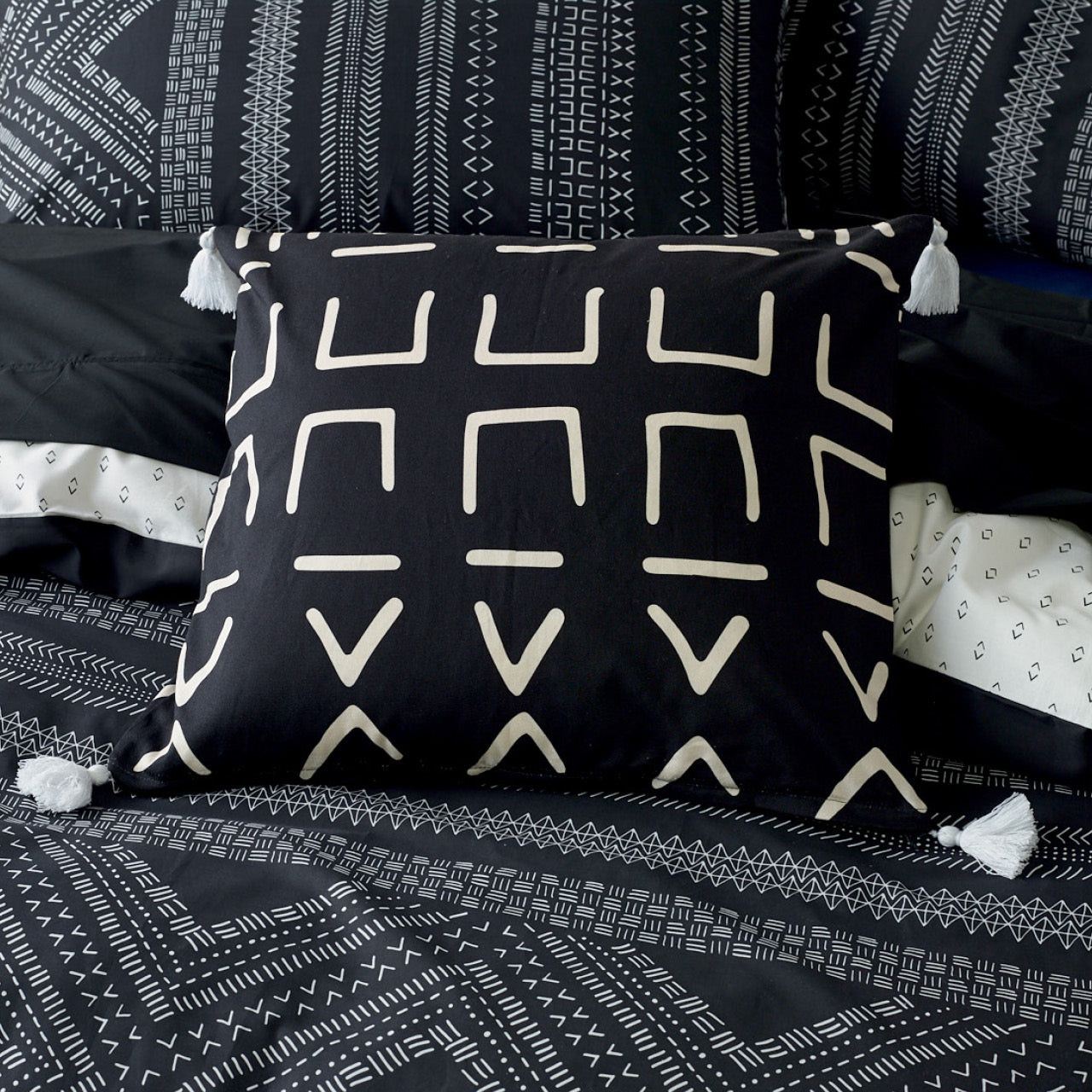 Zoomed in shot of Mursa Cushion Cover on bed