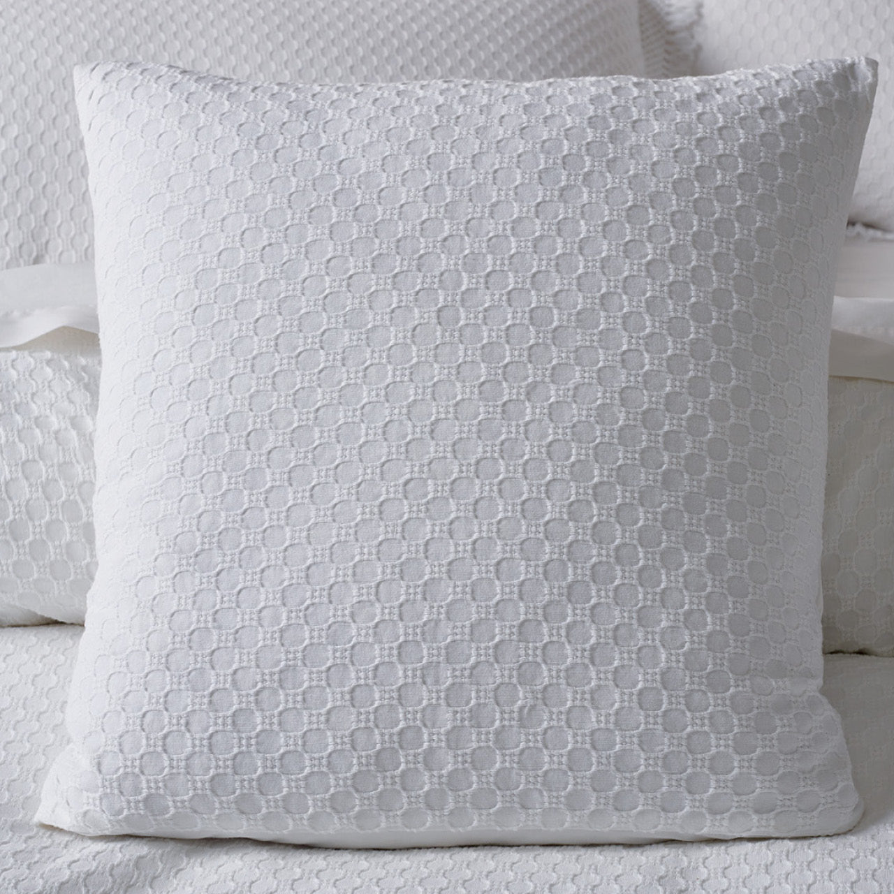 Zoomed in shot of Noosa Cushion Cover on bed
