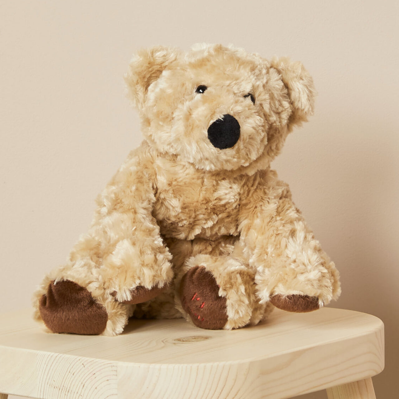 PJ Bear sitting on a stool