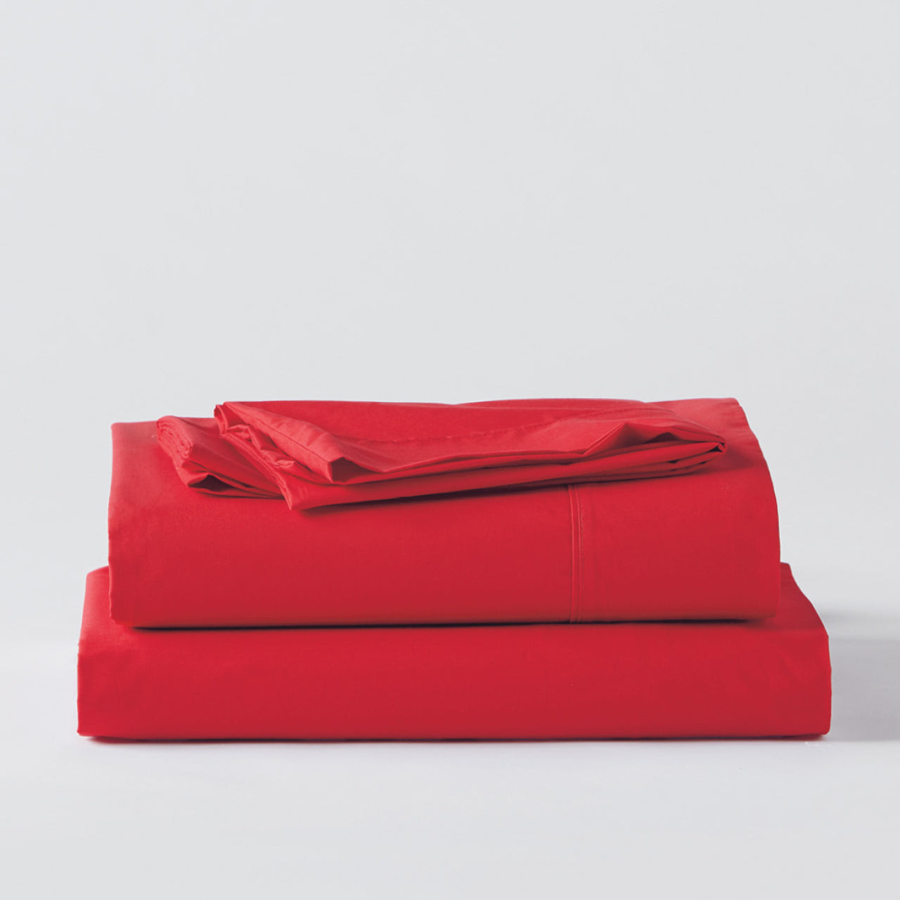 Premium Percale Flame Sheets folded up on floor