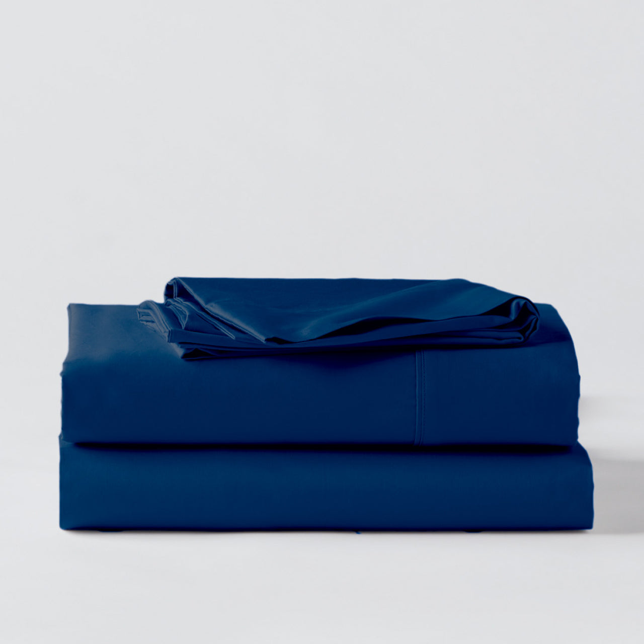 Premium Percale Midnight Sheets folded up on floor
