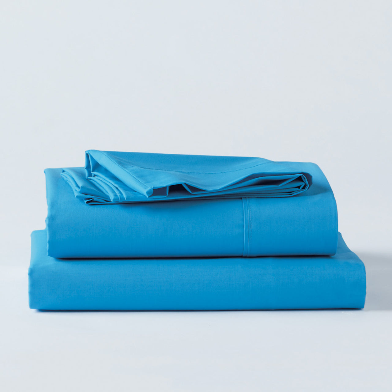 Premium Percale Ocean Sheets folded up on floor