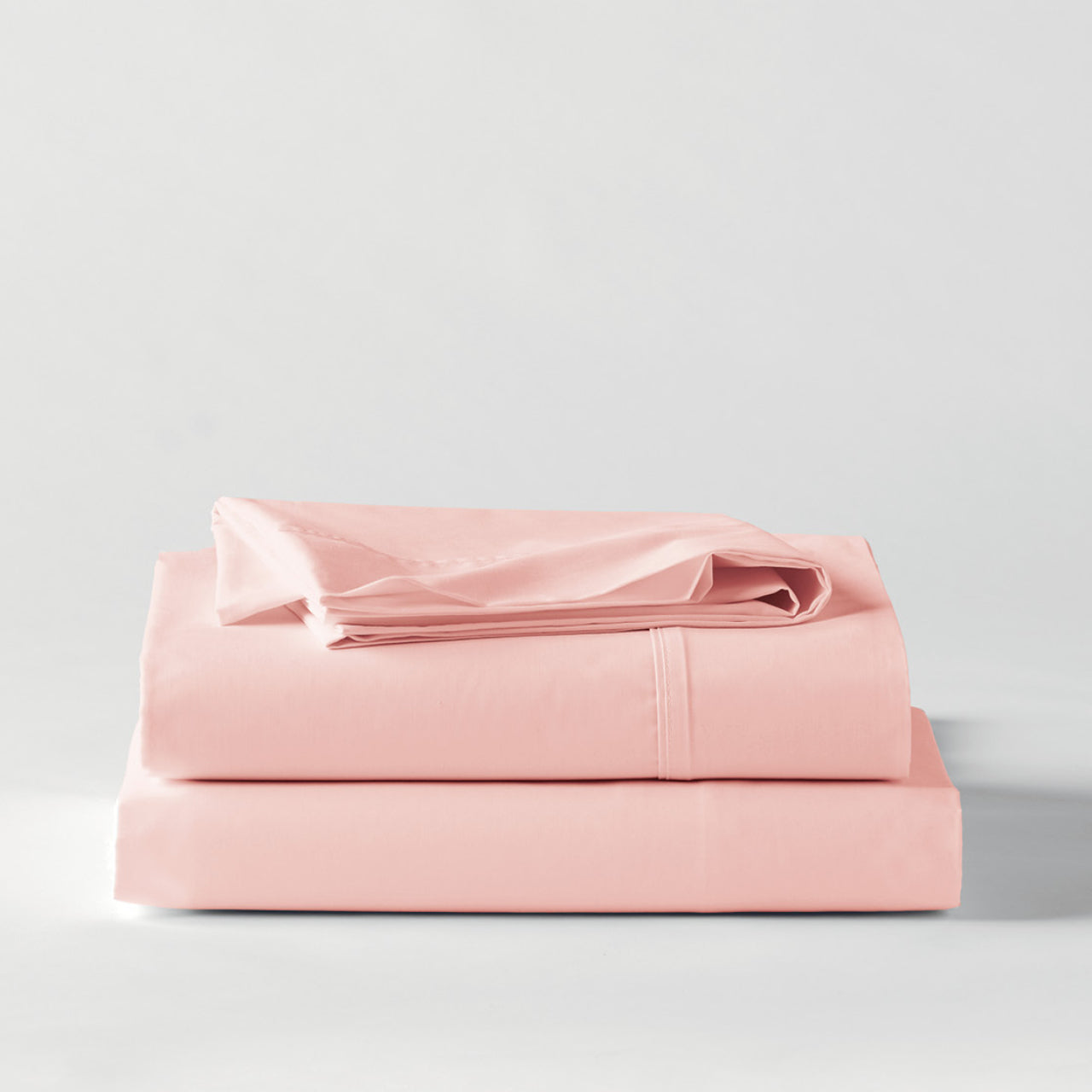 Premium Percale Petal Sheets folded up on floor