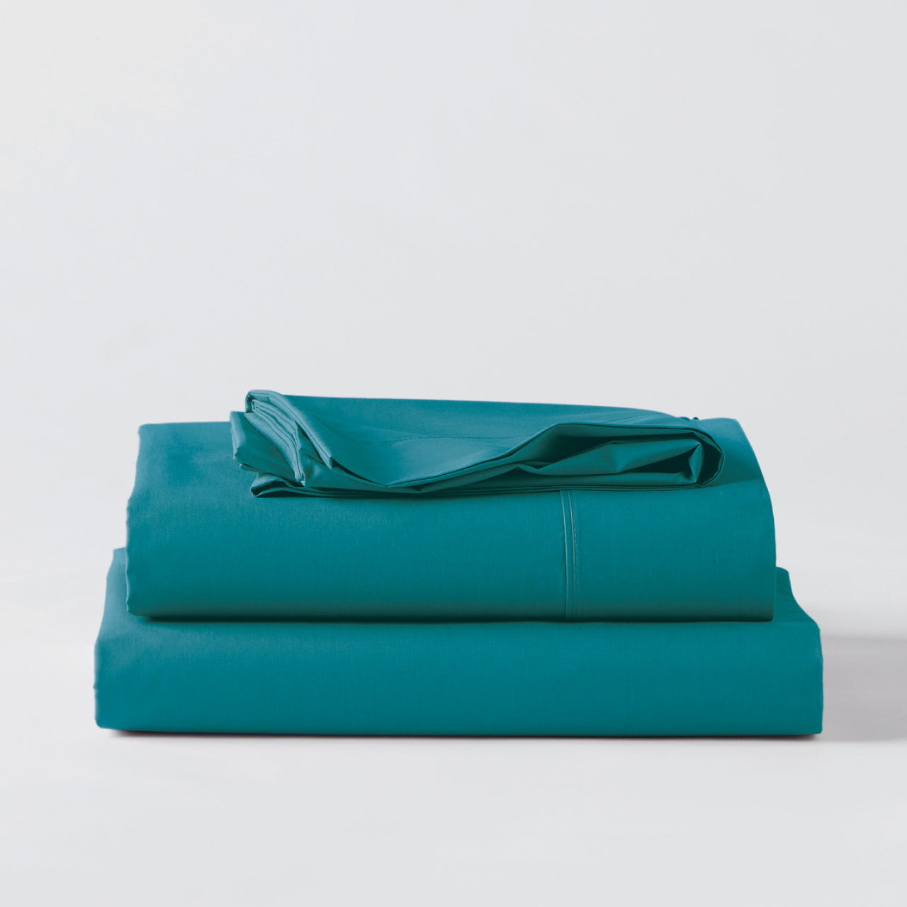 Premium Percale Teal Sheets folded up on floor