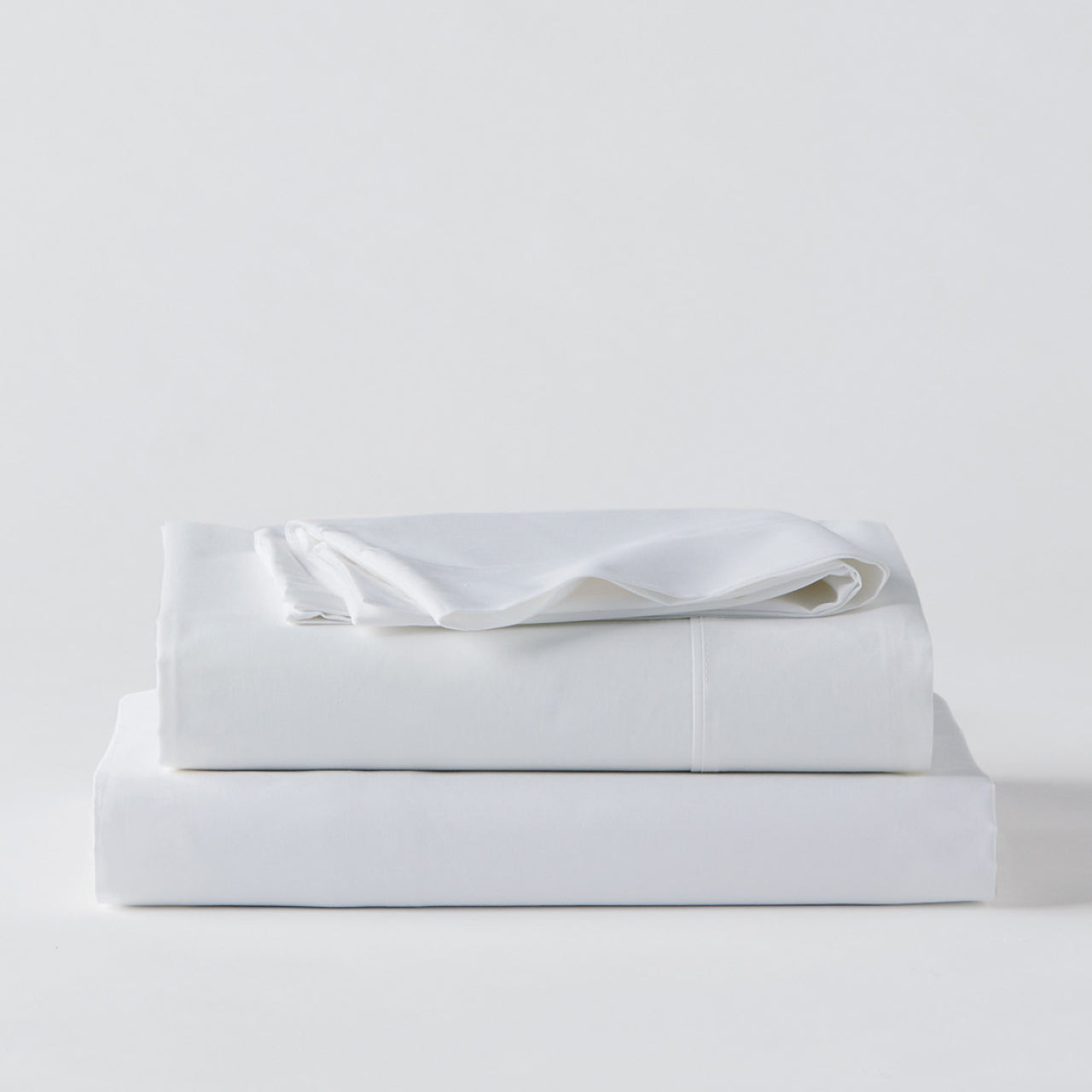 Premium Percale White Sheets folded up on floor
