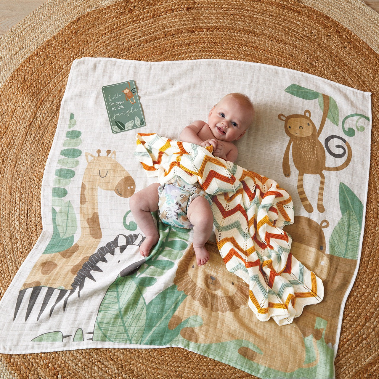 Lifestyle shot of baby on Safari Muslin Blanket with Milestone Cards