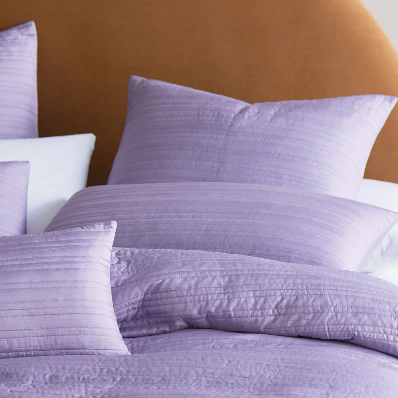 Zoomed in shot of Taya Dusk European Pillowcases on bed