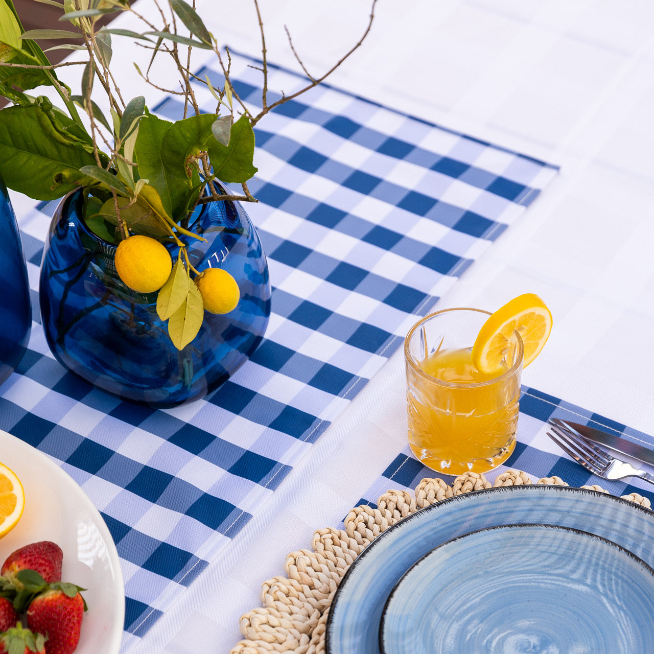 Zoomed in shot of Trinity Table Runner on table with drink and vase with lemons