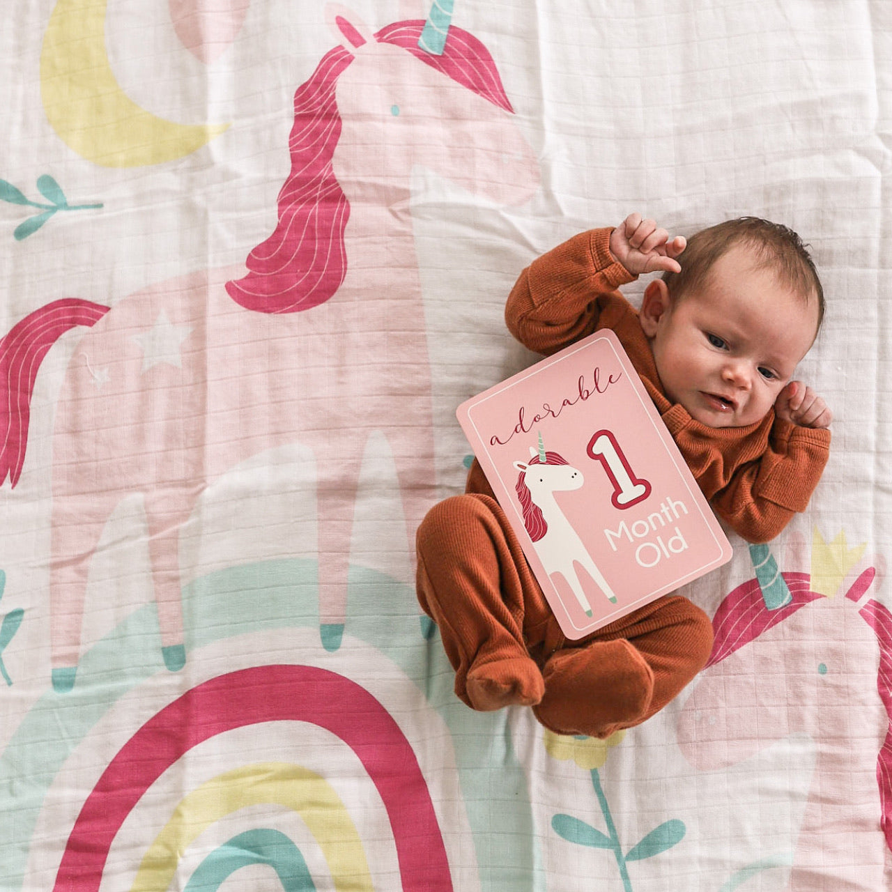 Lifestyle shot of baby with Utopia Muslin Blanket and Milestone Cards