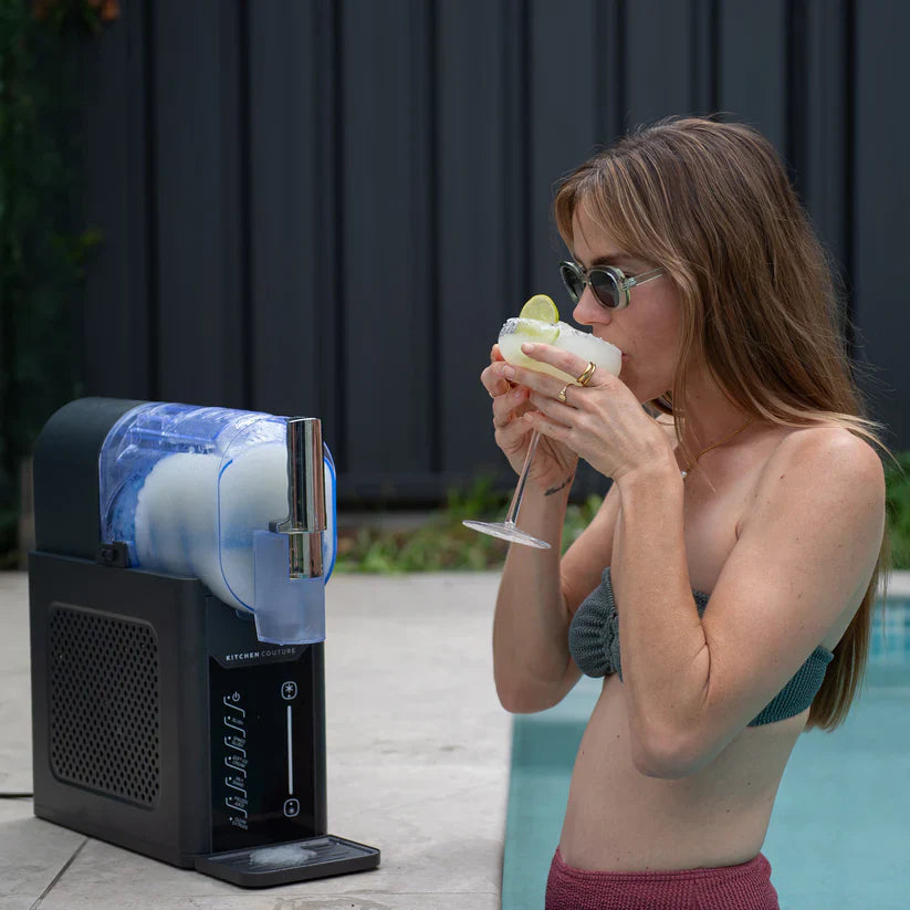 Woman drinking from a slushy machine by a pool