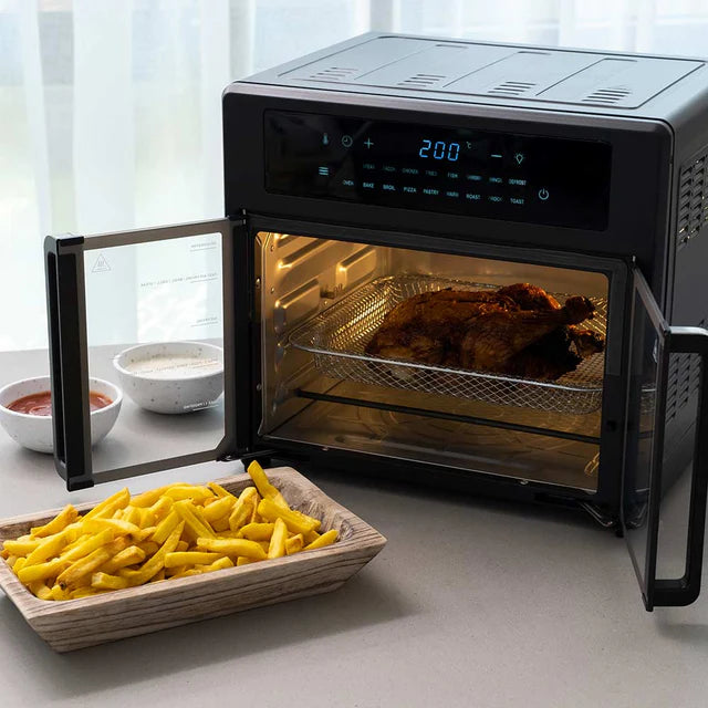 Digital oven with open door showing roasted chicken and fries on a countertop.