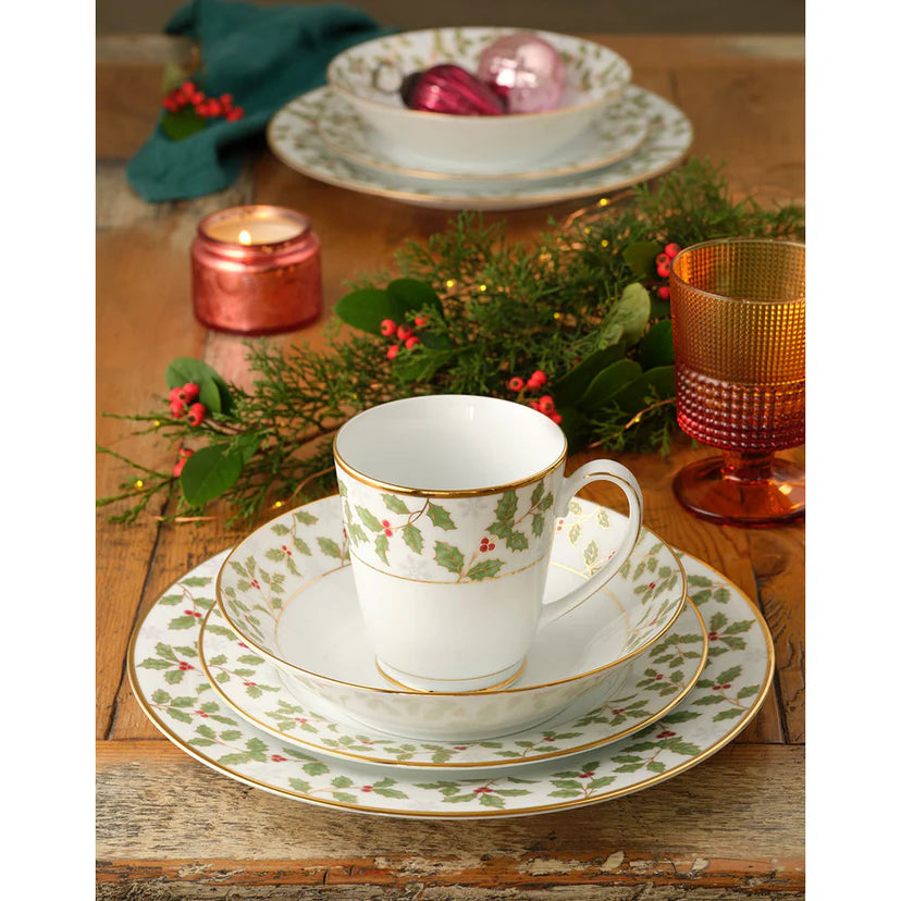 Christmas-themed teacup and saucer set on a wooden table with decorative elements.