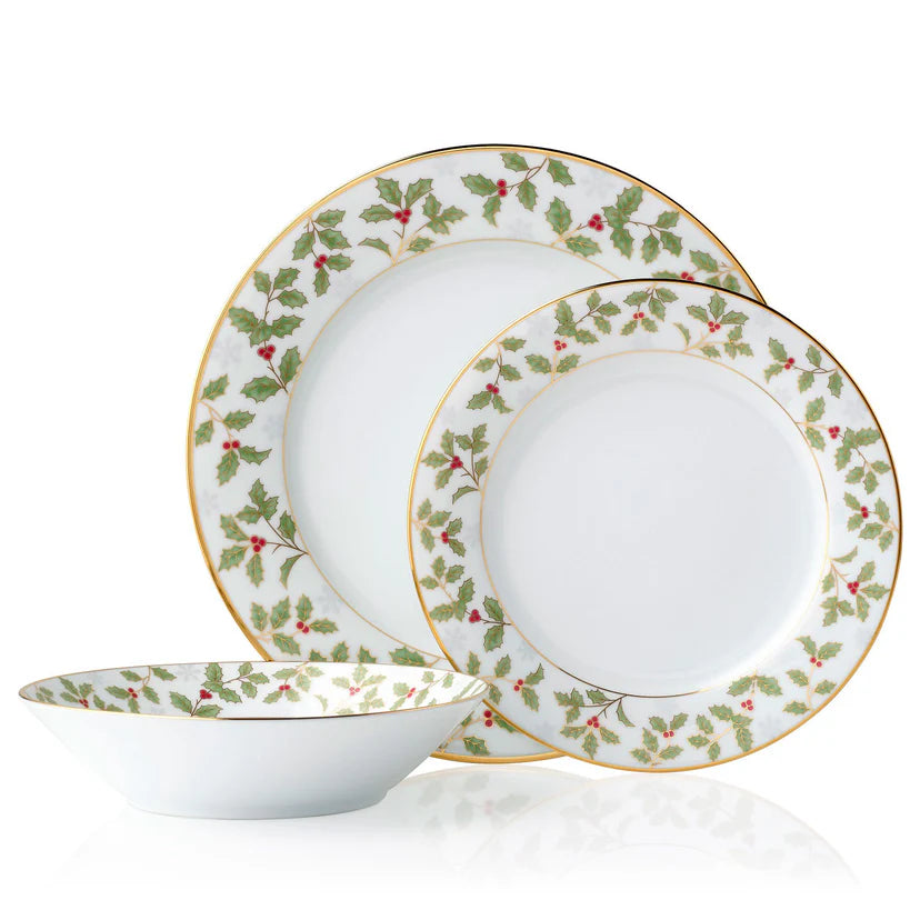 Set of dinnerware with holly berry design on a white background