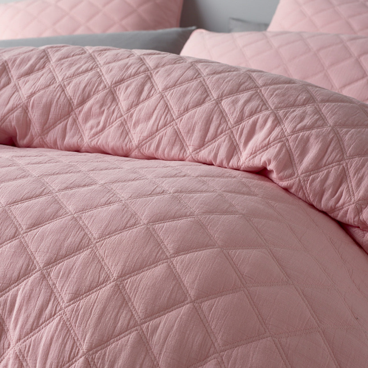 Close up shot of Austin Pink Quilt Cover on bed