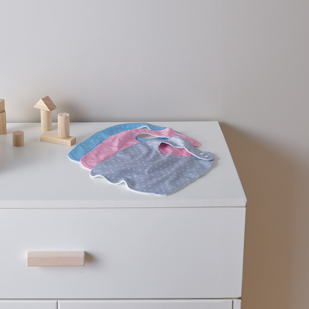 Lifestyle shot of all Baby Basics Bibs on a table