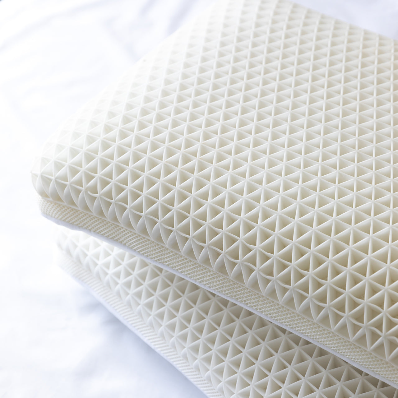 Zoomed in shot of Cool Touch Pillows stacked on bed
