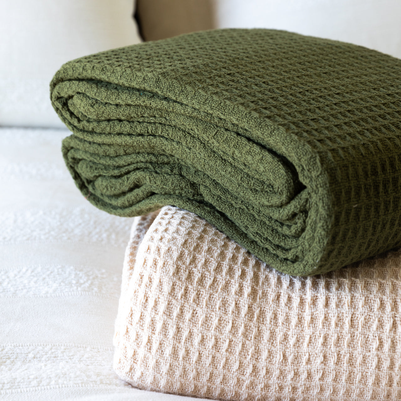 Zoomed in group shot of Cotton Blankets folded up on bed